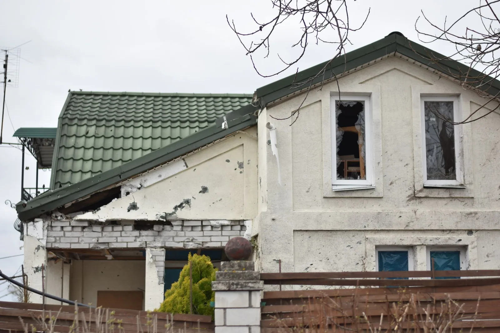 Maison dont la façade et la toiture ont été endommagées, ouvertures béantes