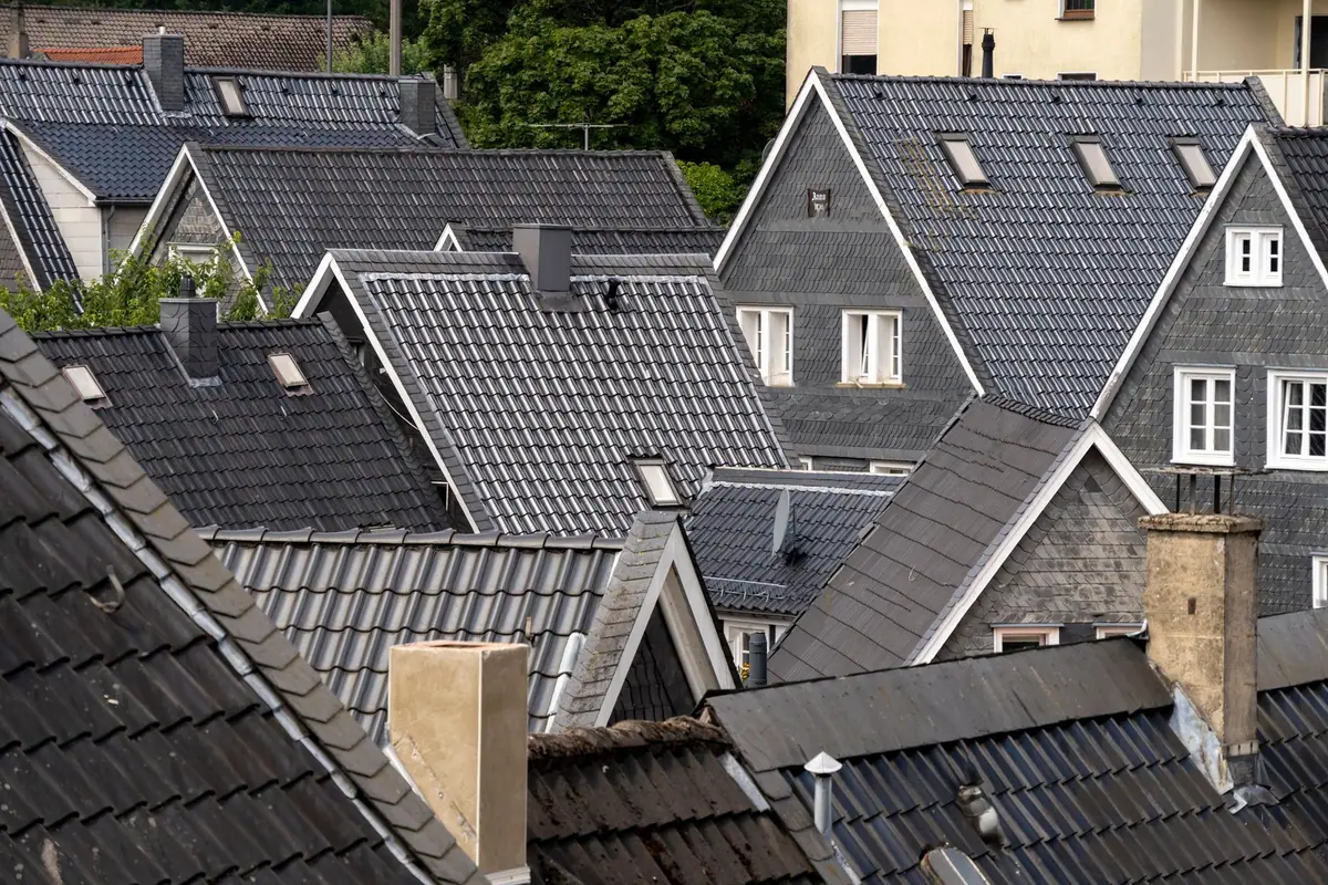 Toits couverts d'ardoises grises régulières sur des maisons à pignons et lucarnes