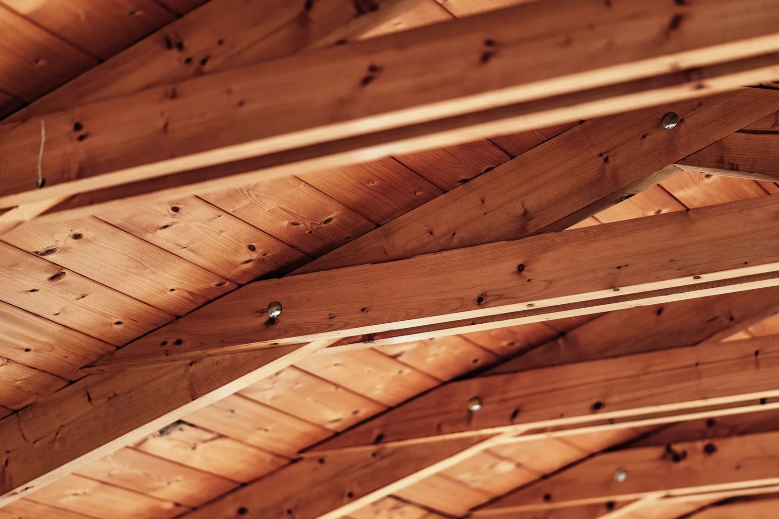 Sous-face d'une toiture : chevrons et voligeage en bois vus depuis les combles