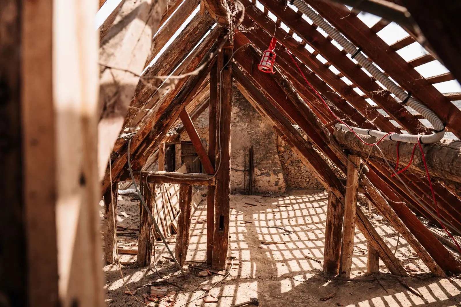 Comble ancien dont la charpente est visible, avec les abouts de pièces encastrés dans la maçonnerie
