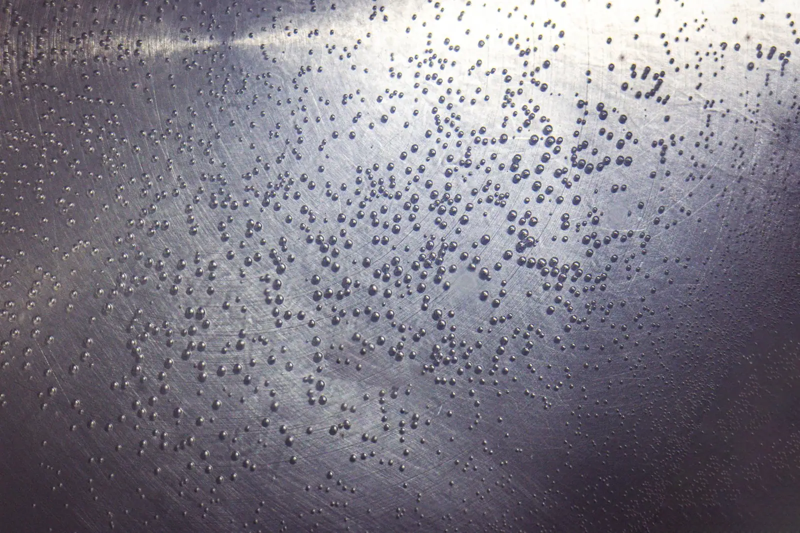 Gouttelettes d'eau dispersées sur une paroi froide, prises à contre-jour