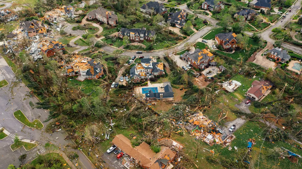 Vue aérienne d'un quartier après une tempête, toitures découvertes et débris au sol