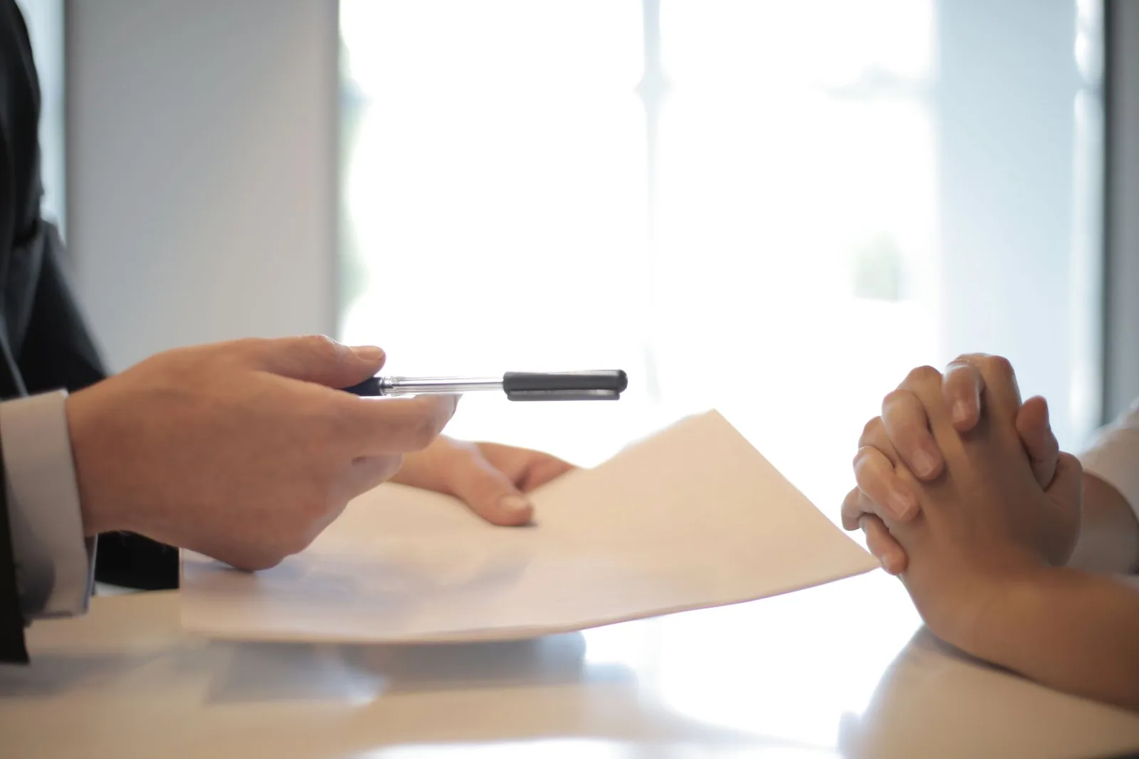 Document tendu par-dessus un bureau, d'une main à l'autre