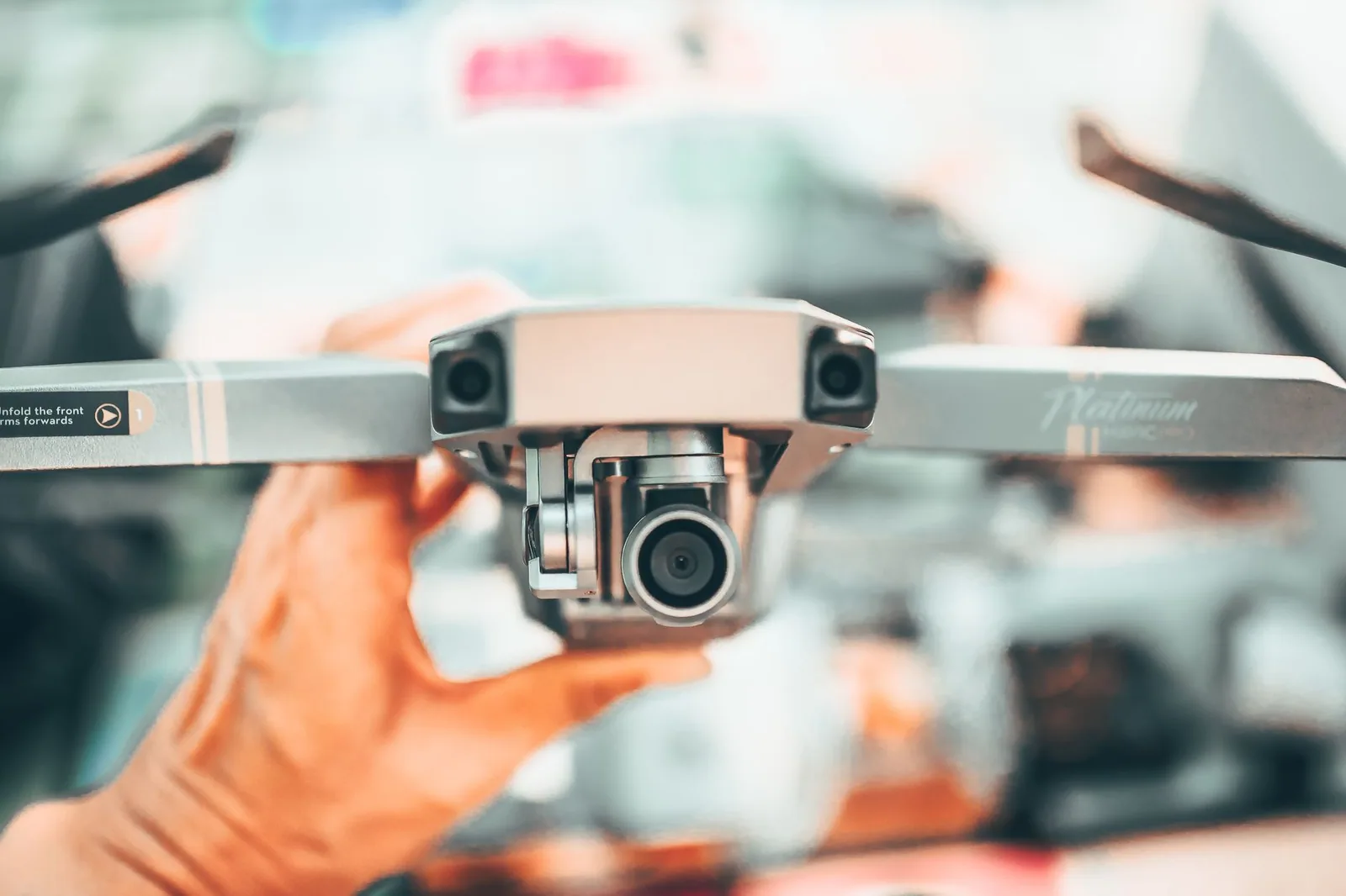 Drone tenu à la main, caméra et hélices visibles de près