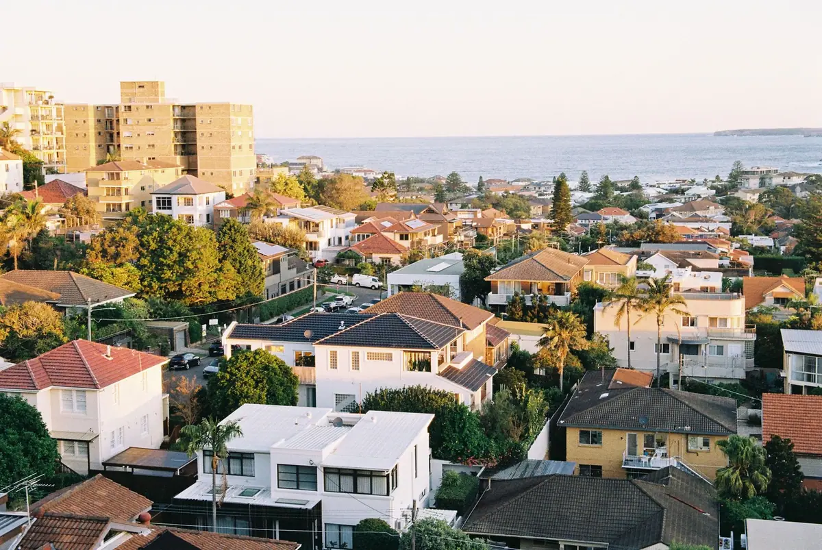 Ville côtière étagée descendant vers la mer, toitures de tuiles et immeubles bas