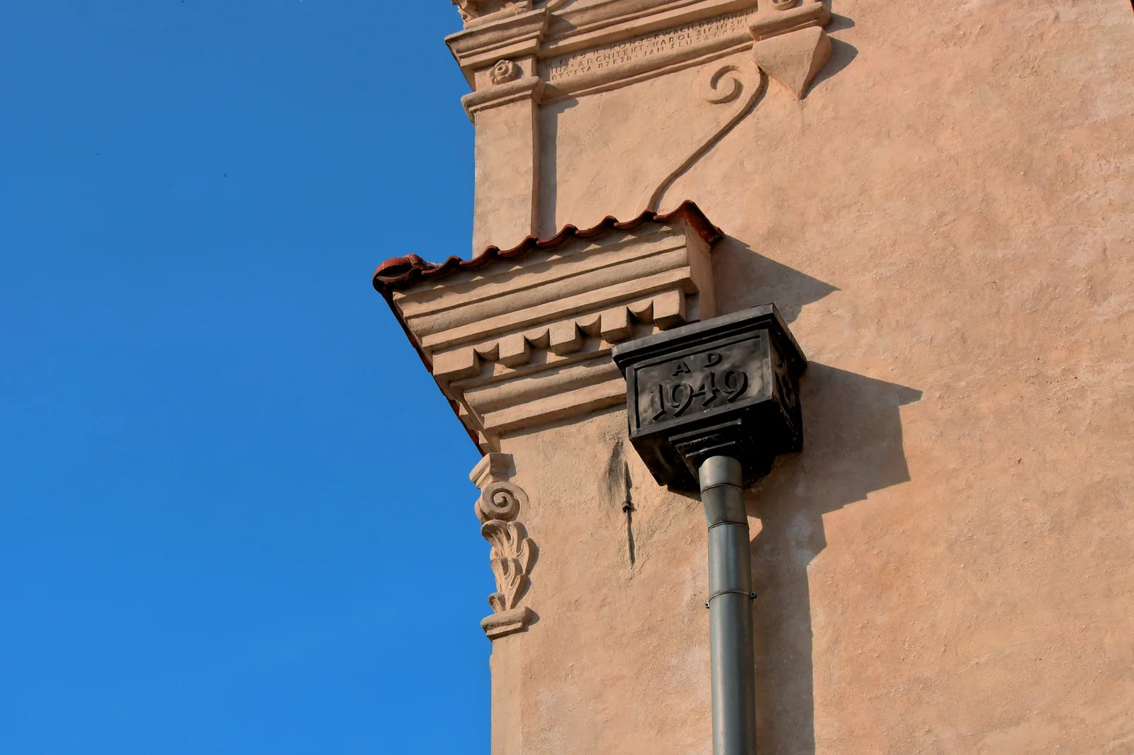 Cuvette de descente ouvragée et datée, posée sous une corniche moulurée d'un bâtiment ancien