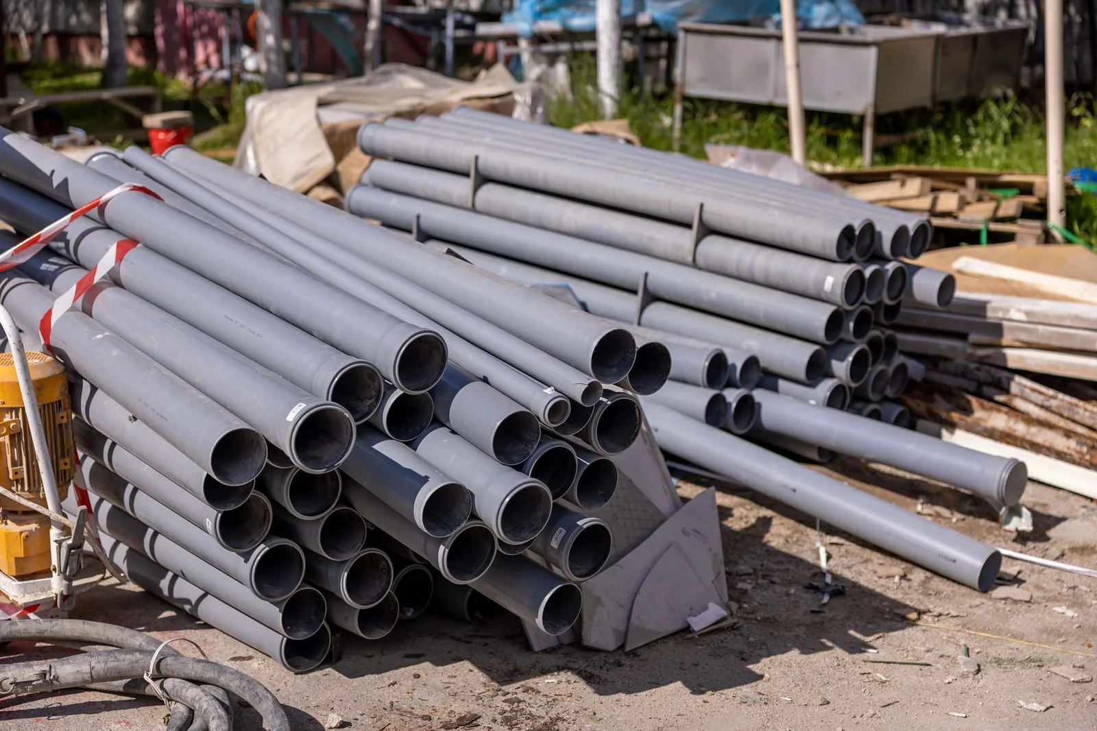 Tubes plastiques gris empilés sur un chantier
