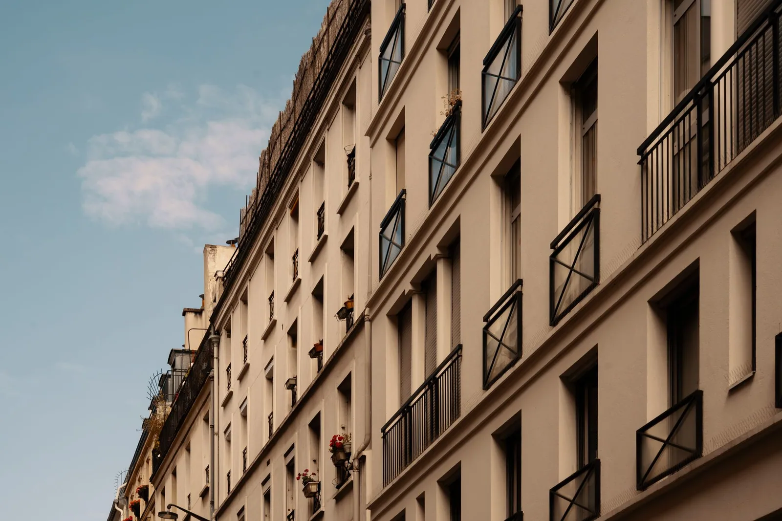 Façade d'un immeuble ancien aux balcons en fer forgé, vue en contre-plongée