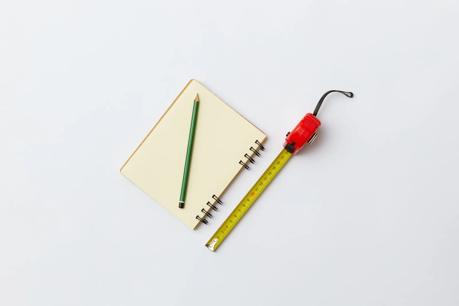 Mètre ruban et crayon posés sur un carnet