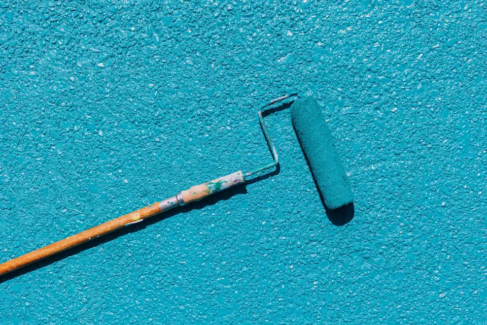 Rouleau de peinture posé sur une surface fraîchement peinte