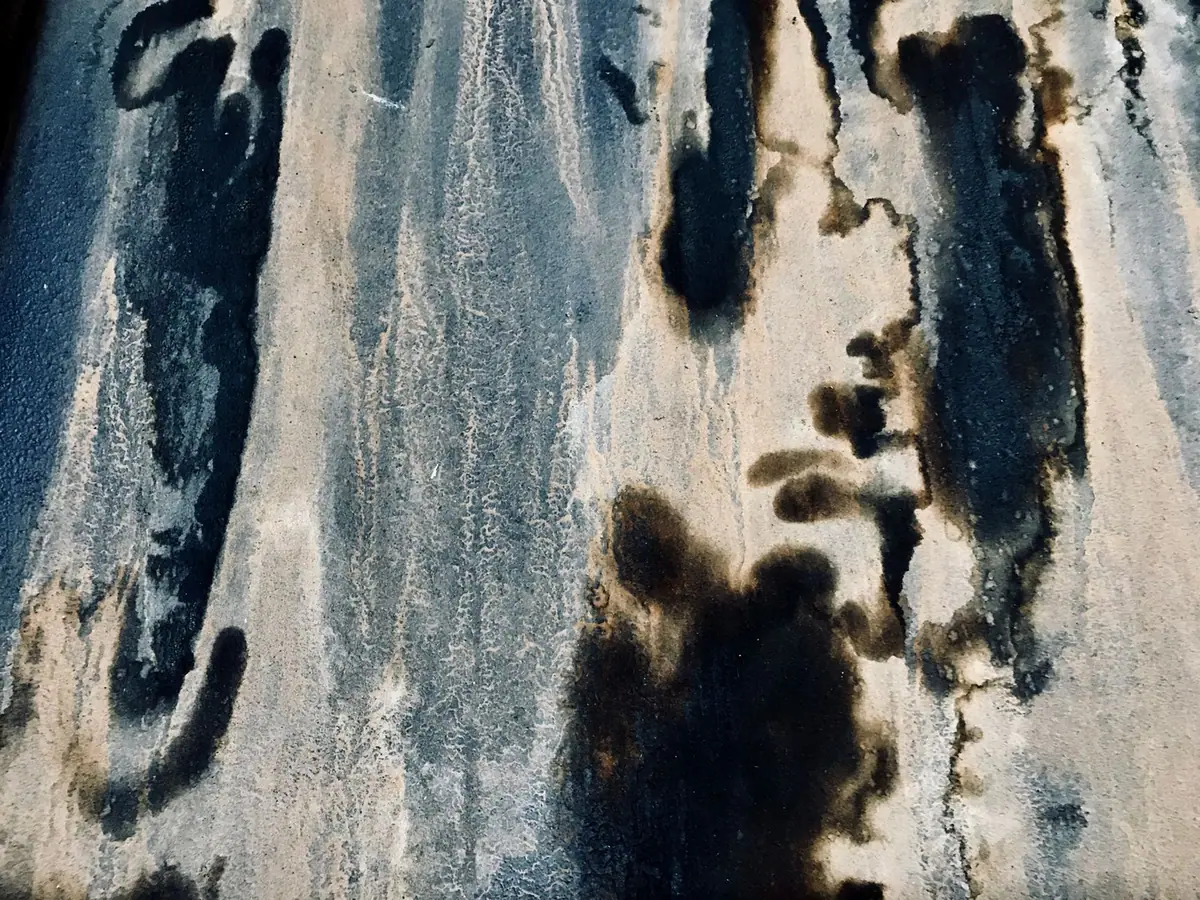 Coulures sombres et auréoles sur une surface claire