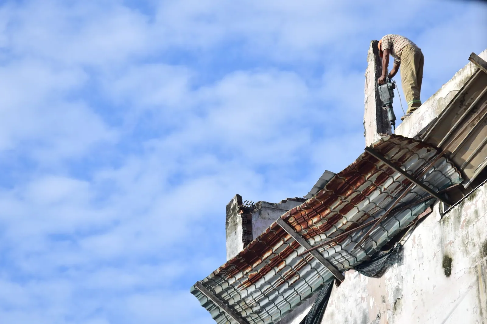 Haut d'un mur et rive de toiture fortement dégradés, éléments manquants