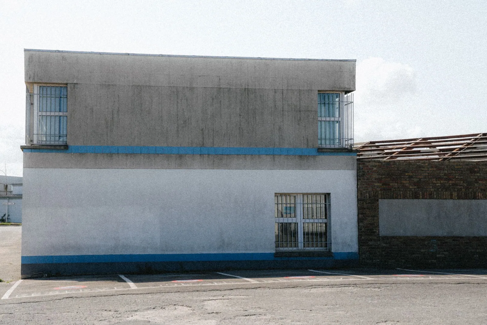 Bâtiment à toit plat vu depuis la rue, acrotère continu bordant toute la toiture