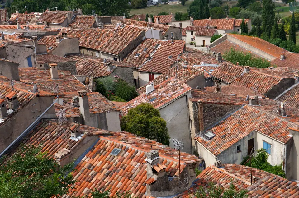 Vue plongeante sur un quartier ancien aux toitures de tuiles rondes, de pentes et d'orientations différentes