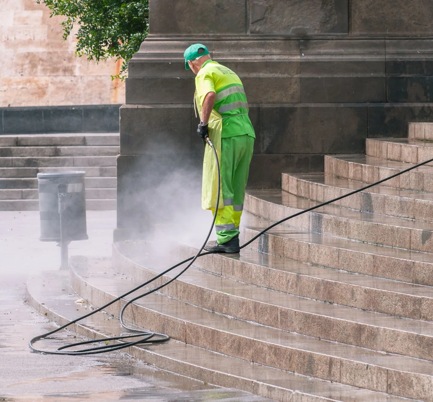 Opérateur nettoyant à la vapeur des marches en pierre, panache blanc au ras du support