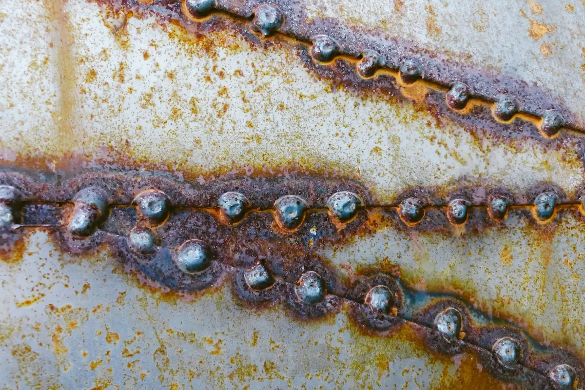 Assemblage métallique ancien, riveté, couvert de rouille sur toute sa longueur